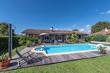 A house with a large swimming pool in front of it
