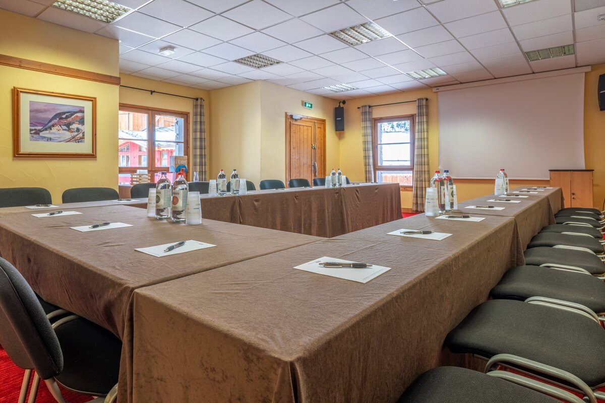 A conference room set up with long tables and chairs