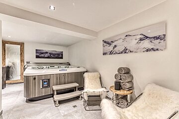 A room with a hot tub and a picture of mountains on the wall