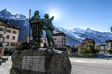 A statue of two men with mountains in the background