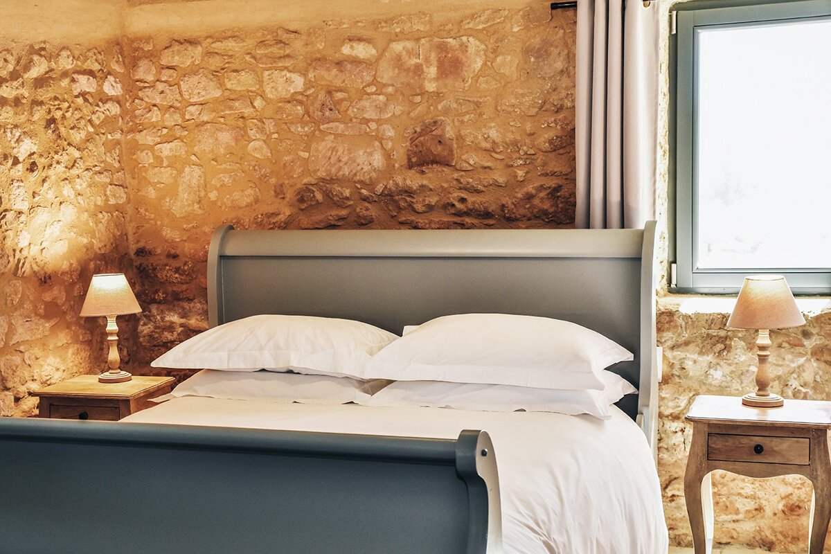 A bedroom with a sleigh bed and two lamps