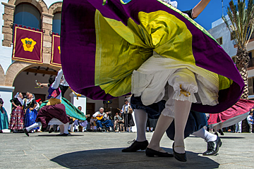 A woman in a purple and yellow dress is dancing