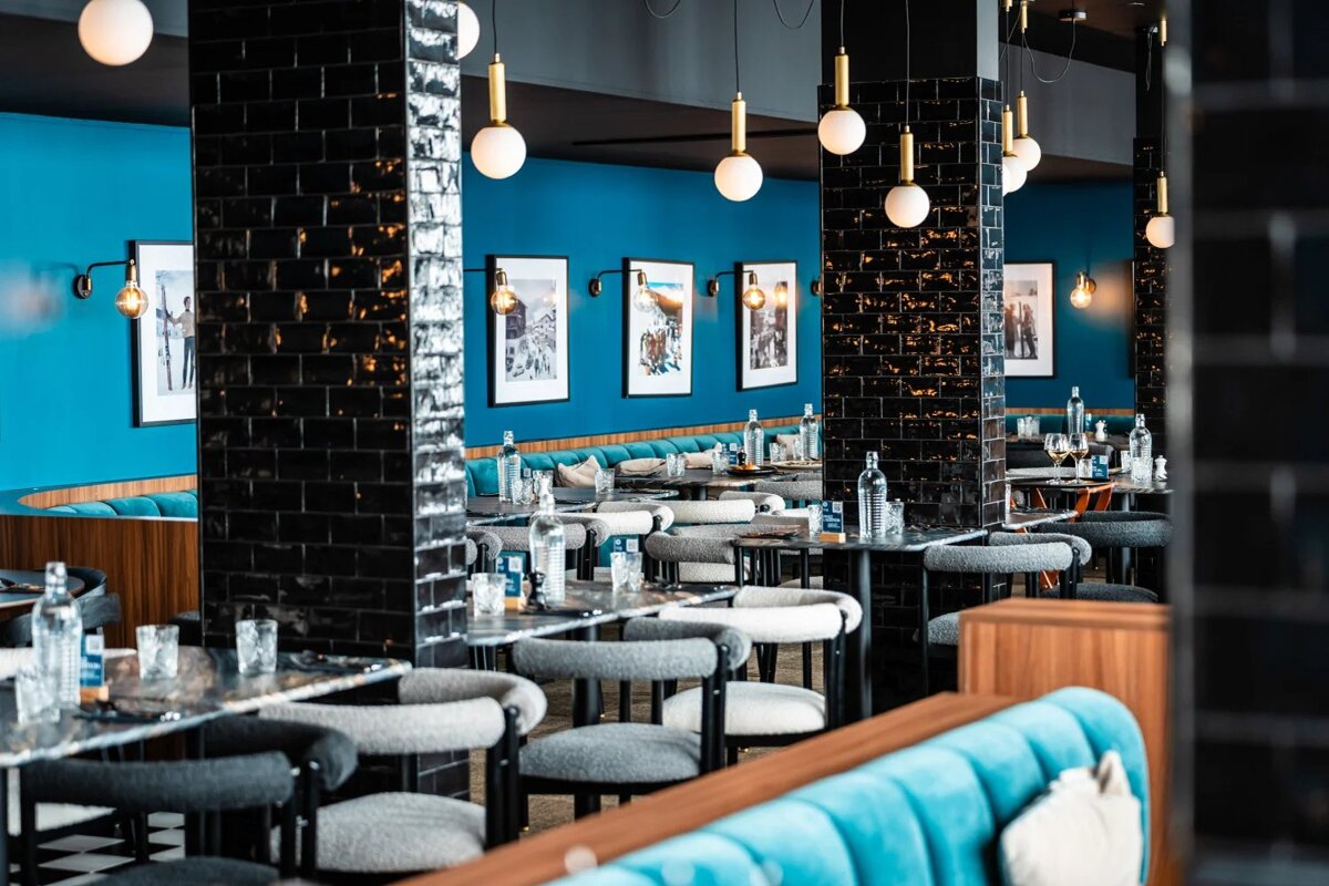 A restaurant with blue walls and tables and chairs