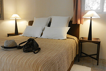 A bed with a hat and a purse on it