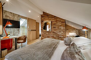 A bedroom with a brick wall and a bed