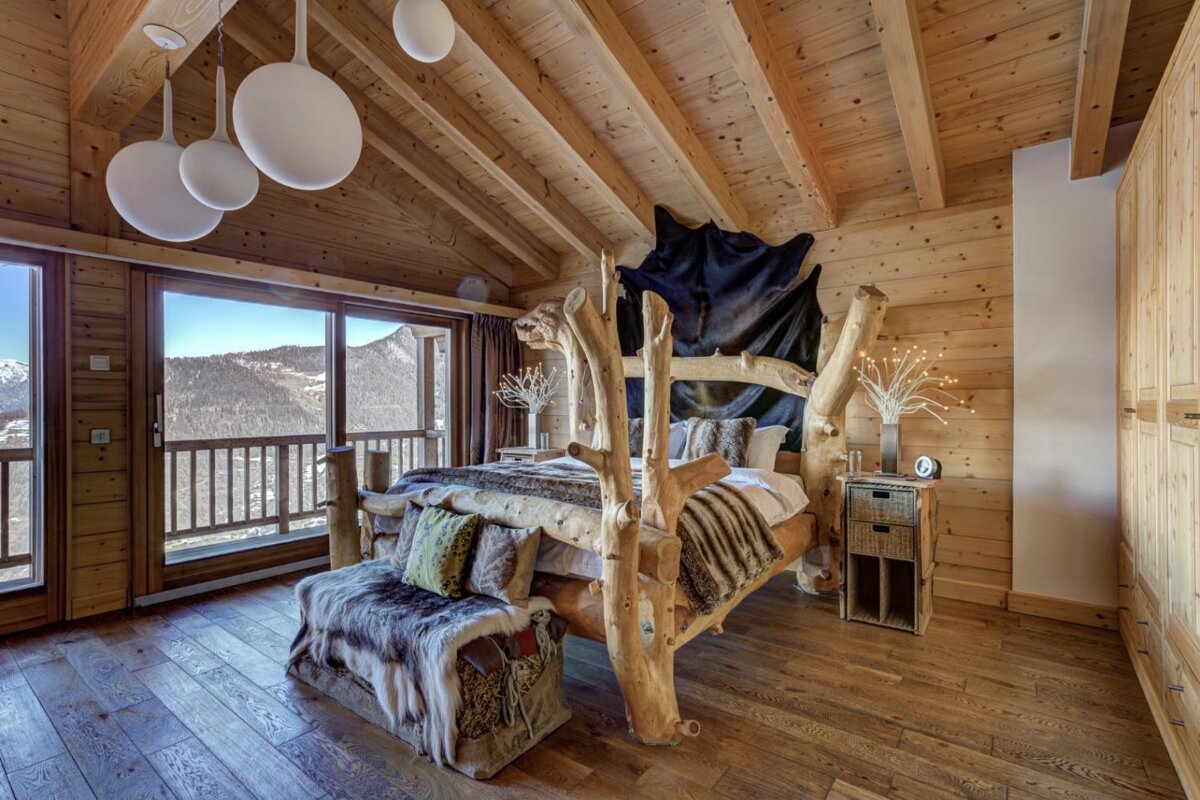 A bedroom with a wooden bed and a large window