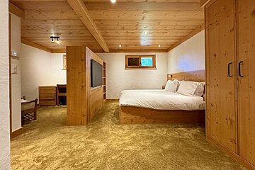 A bedroom with a large bed and a flat screen tv
