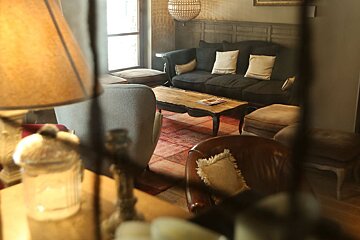 A living room with a black couch and white pillows