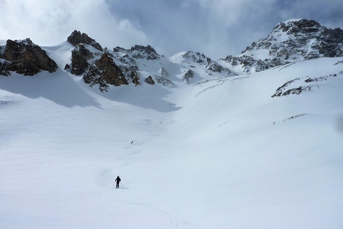 skiers in an off piste bowl