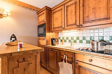 A kitchen with wooden cabinets and a candle on the counter
