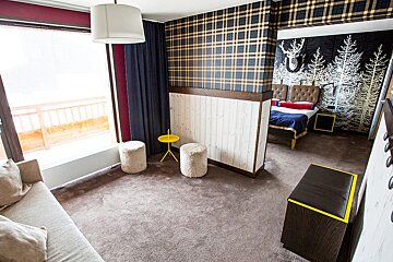 A room with a couch and two ottomans in it