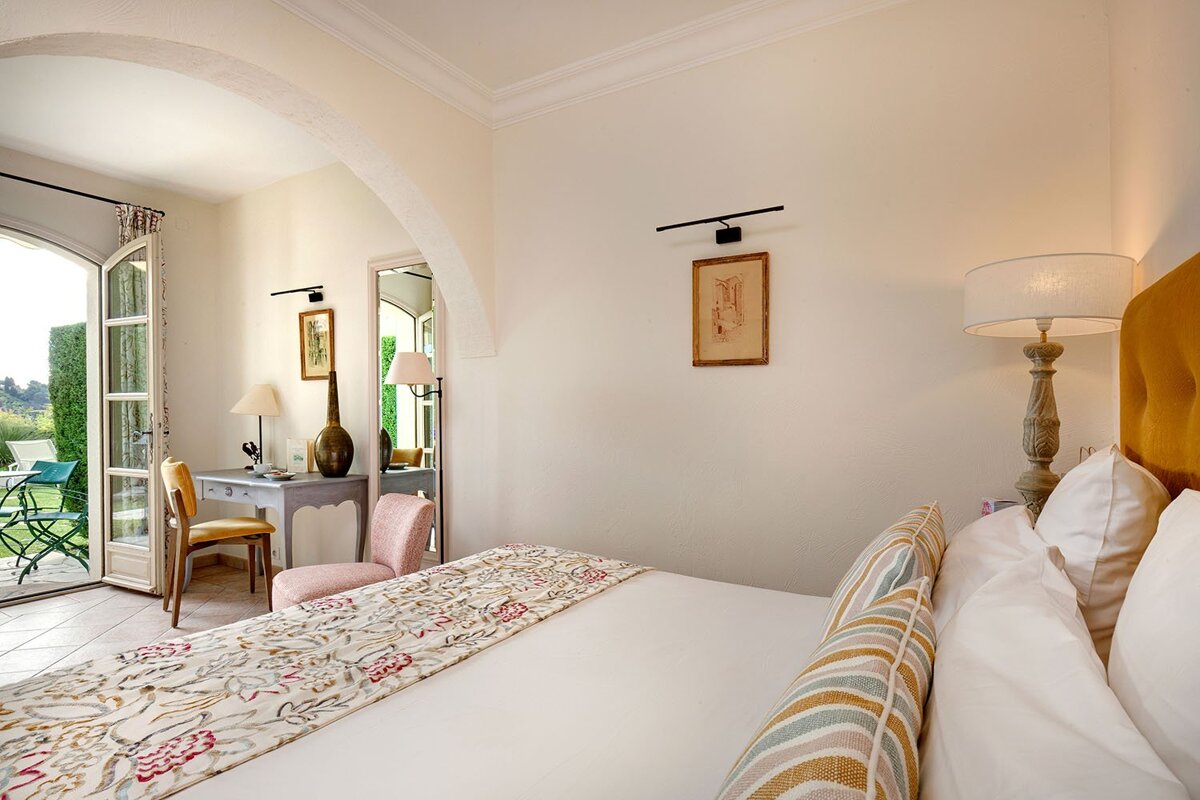 A bedroom with a large bed and a desk