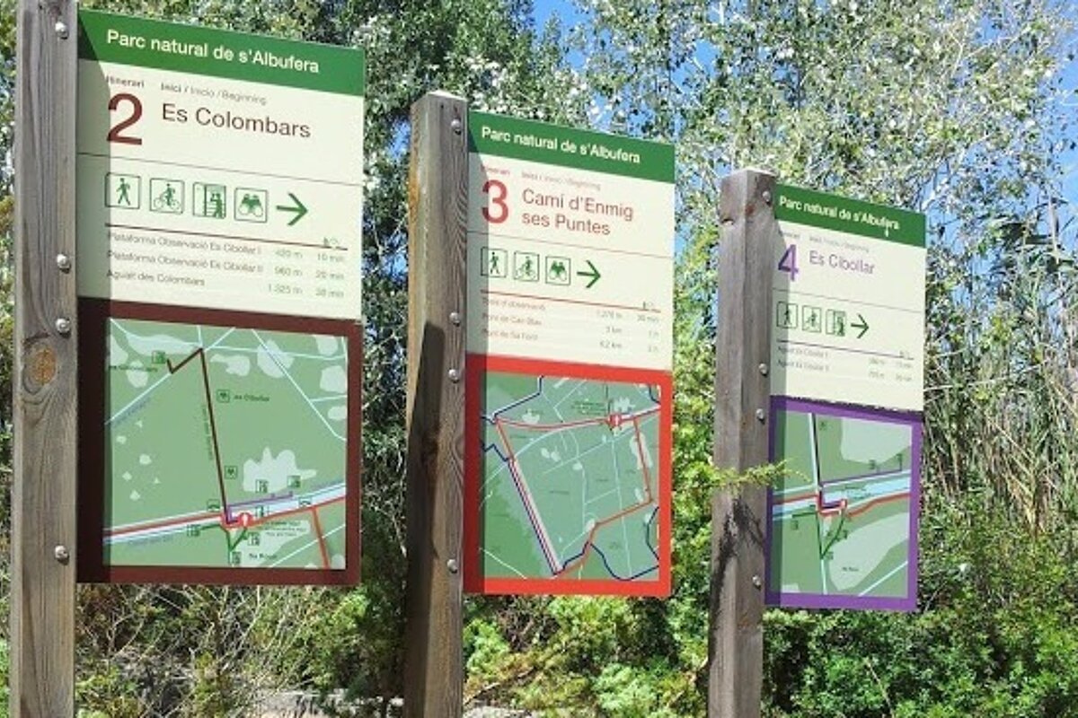 three signs showing different walking paths