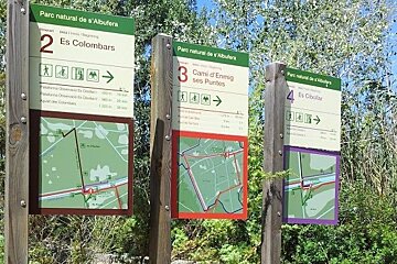 three signs showing different walking paths