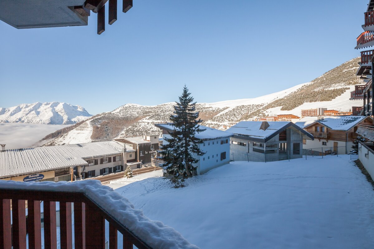 A balcony overlooking a snowy village with a sign that says ' montagne ' on it