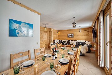 A bottle of wine sits on a wooden table in a living room