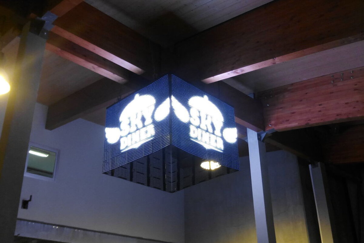 LED sign that says Skydiner hanging from the ceiling on some beams