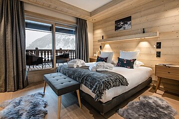 A bedroom with a large bed and a large window