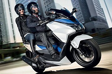 A man and a woman are riding a honda scooter