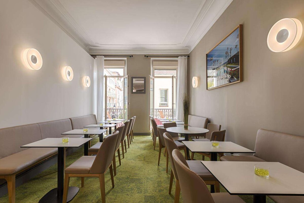 A room with tables and chairs and a picture on the wall