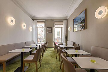 A room with tables and chairs and a picture on the wall