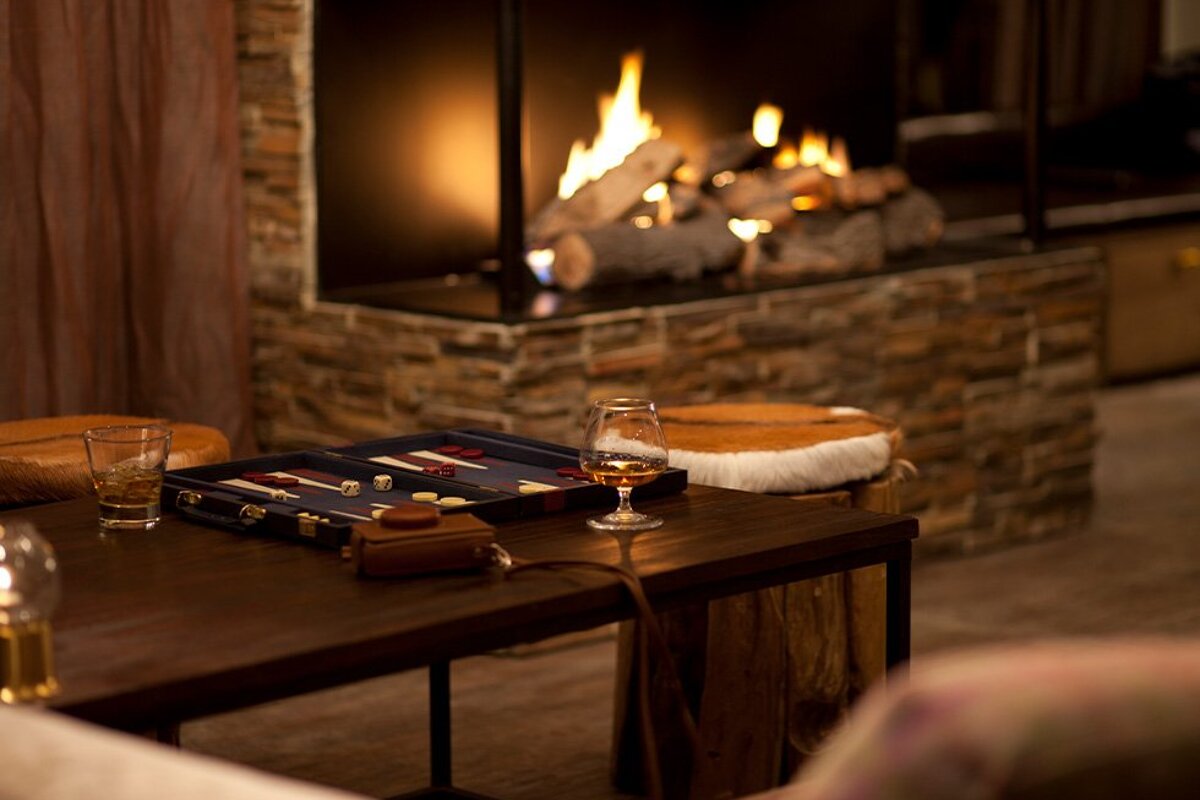 A game board sits on a table in front of a fireplace