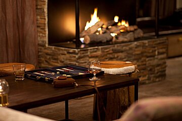 A game board sits on a table in front of a fireplace