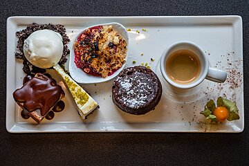 A plate of desserts and a cup of coffee on a table