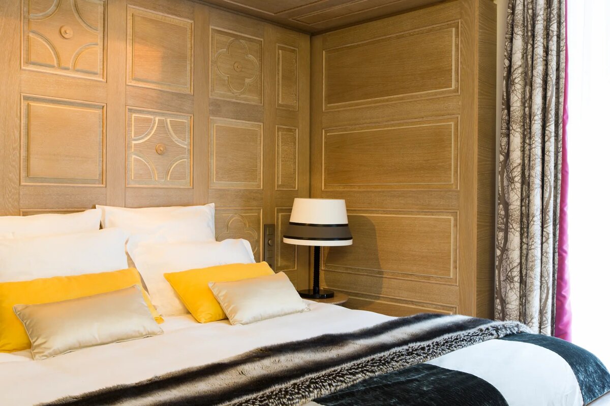 A bed with yellow pillows and a lamp on it