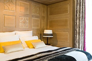 A bed with yellow pillows and a lamp on it