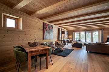 A living room with a wooden table and chairs