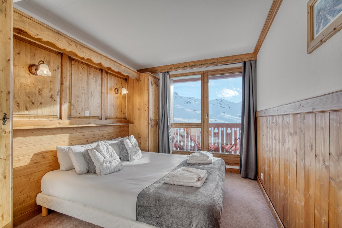 A bedroom with a large bed and a balcony