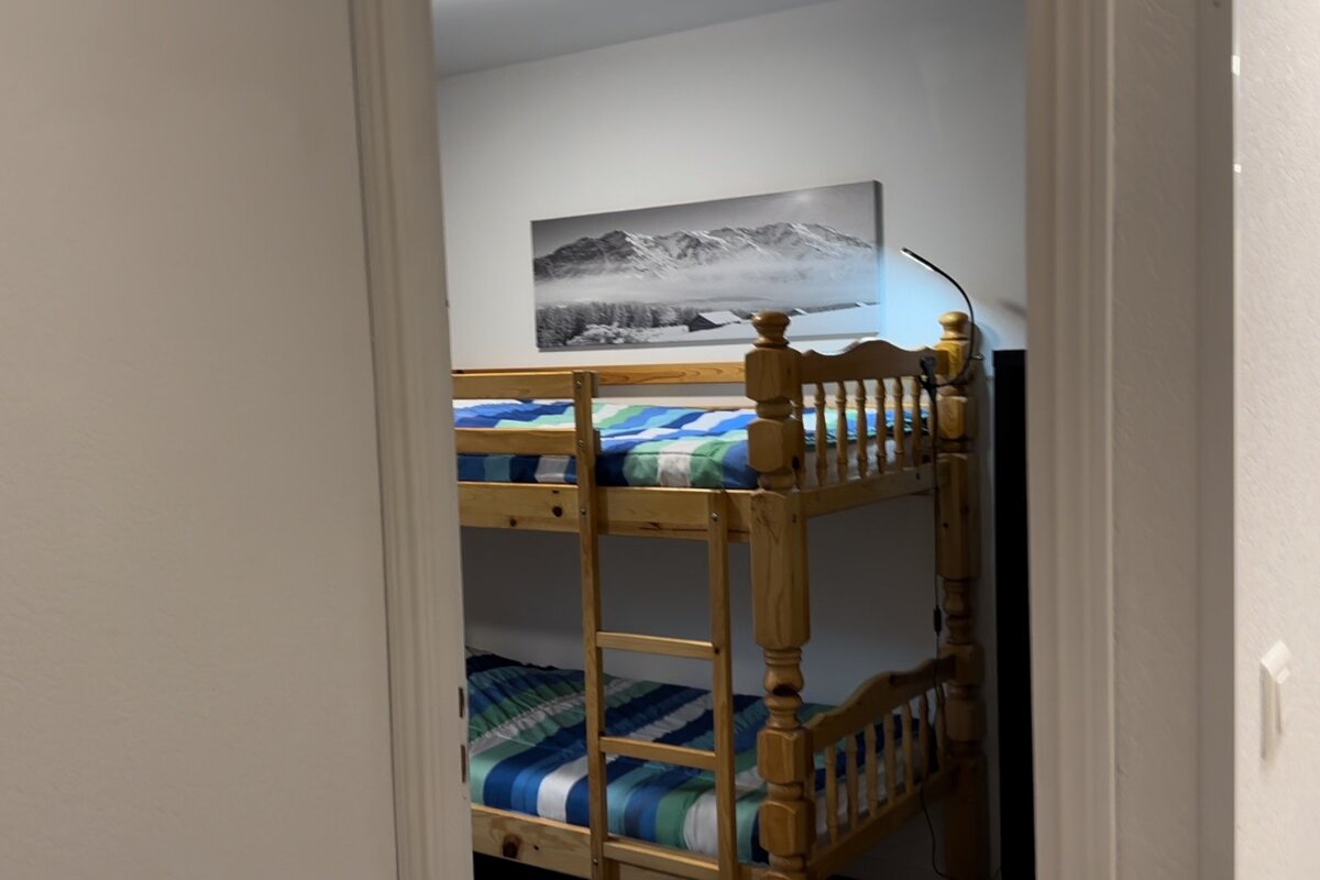 A bunk bed with a picture of mountains on the wall above it