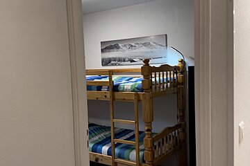 A bunk bed with a picture of mountains on the wall above it