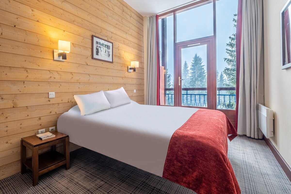 A hotel room with a large window and a bed