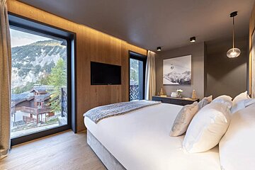 A bedroom with a large bed and a flat screen tv