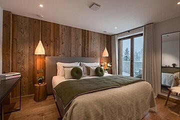 A bedroom with a large bed and a book on a desk that says ' i love you ' on it