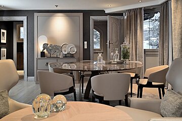 A dining room with a round table and chairs
