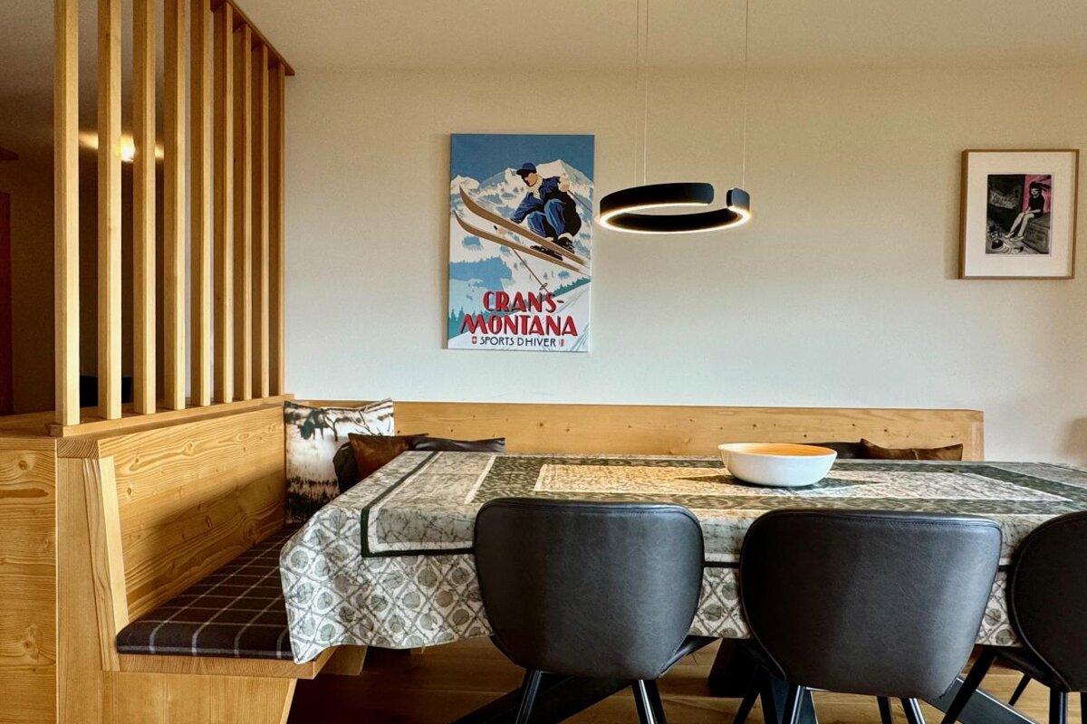 A dining room with a crans montana poster on the wall
