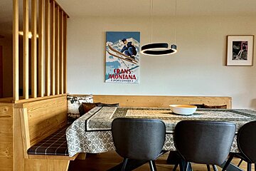 A dining room with a crans montana poster on the wall
