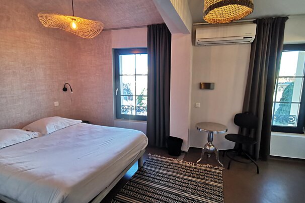 A bedroom with a large bed and a small table