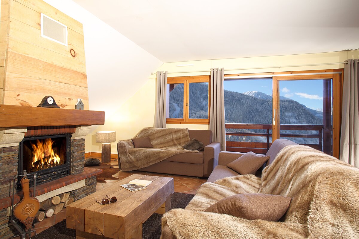 A living room with a fireplace and a view of the mountains