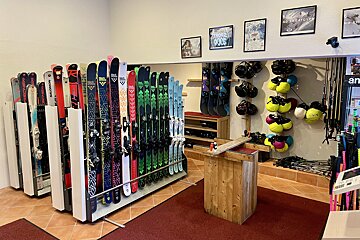 A display of skis and snowboards including one that says salomon