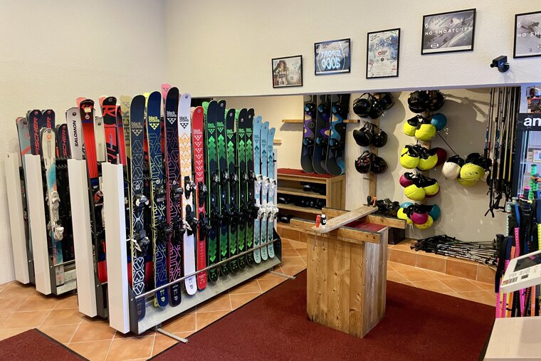 A display of skis and snowboards including one that says salomon