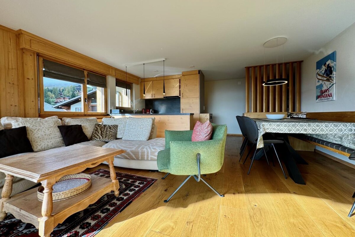 A living room with a couch a chair and a dining table