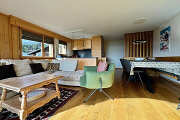 A living room with a couch a chair and a dining table