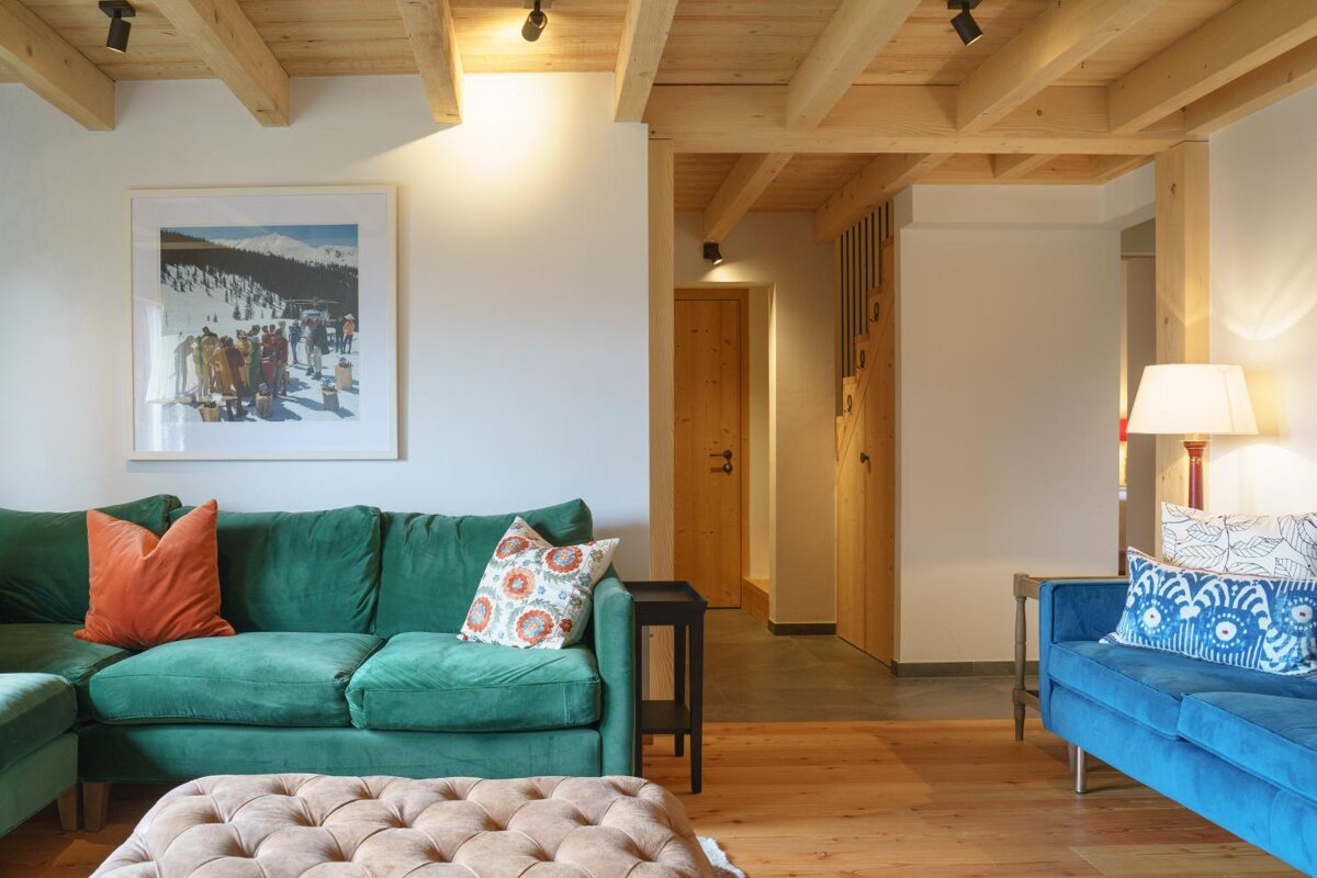 A living room with a green couch and a blue couch