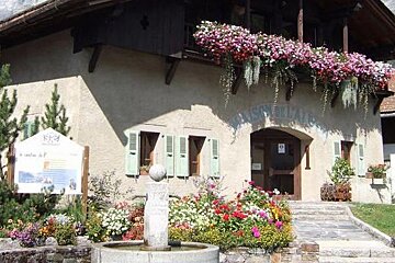 a stone building with lots of flowers outside