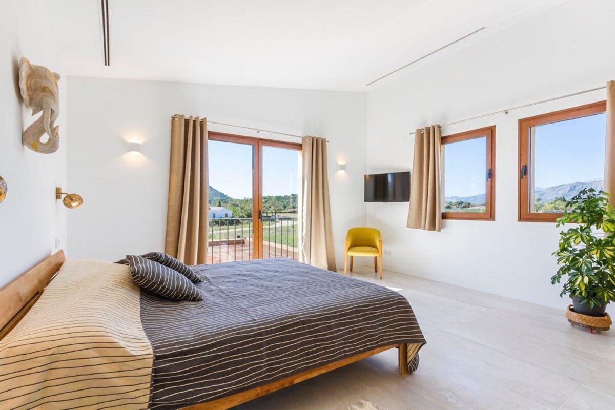 A bedroom with a large bed and a yellow chair