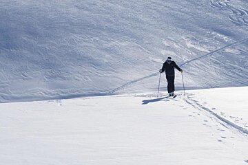 A SKIER SKIING UP THE HILL